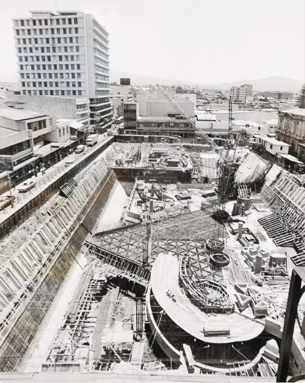 La imagen muestra las excavaciones y obras de infraestructura necesarias para desarrollar este importante espacio urbano, así como la maquinaria pesada, materiales de construcción y personal trabajando en el sitio.