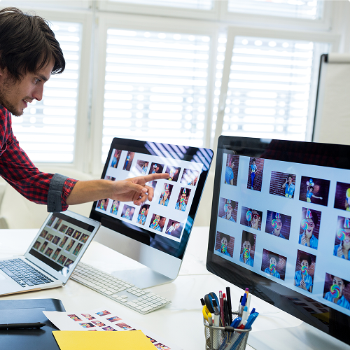 Diseñadores Gráficos Masculino y Femenino Interactuando con la Computadora